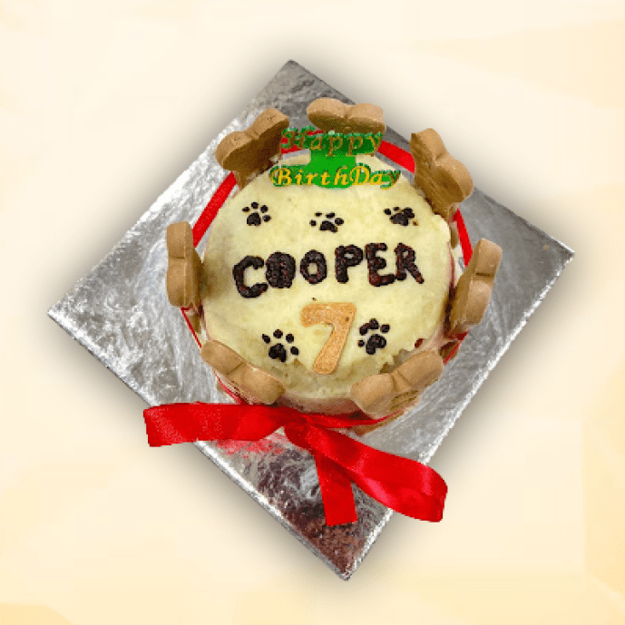 Bone Crown Cake for dogs topped with name, number, and biscuit bones, wrapped in red ribbon.