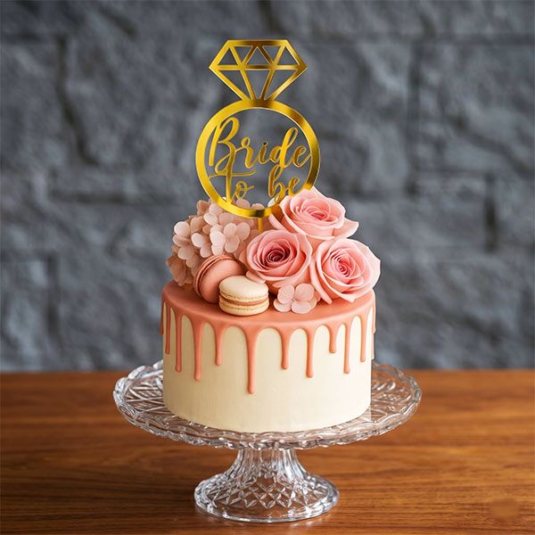 bride to be drip cake with floral topper