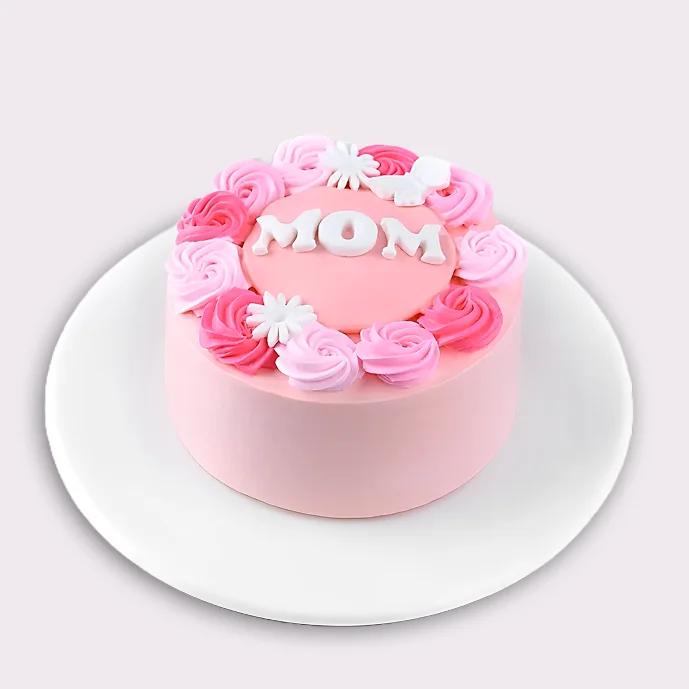 Pink Mother’s Day cake decorated with white “MOM” letters and pink rose swirls