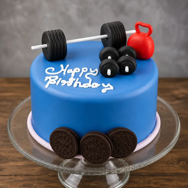 Blue birthday cake topped with a barbell, dumbbells, red kettlebell, and an Oreo cookie base.