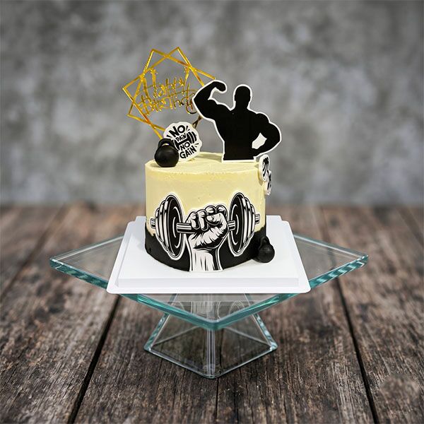 Cream and black two-tone cake with bodybuilder silhouette and hand gripping a dumbbell graphic.