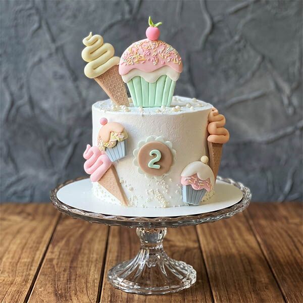 Pastel cake with 2nd birthday topper, fondant cupcakes, and ice cream cones