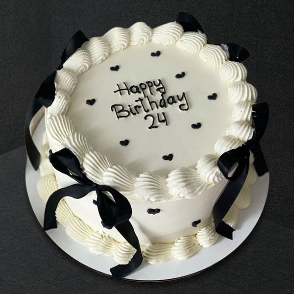 white cake with black ribbon