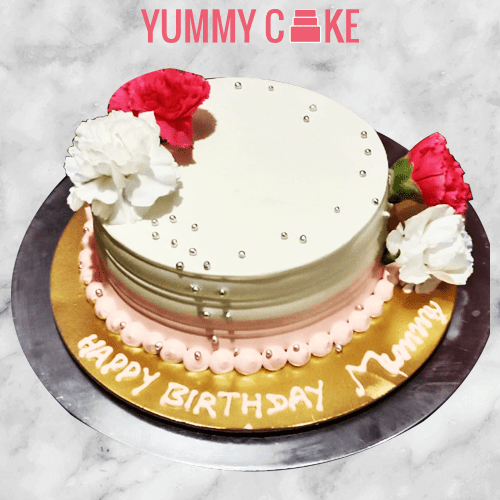 Birthday cake decorated with pink and white flowers