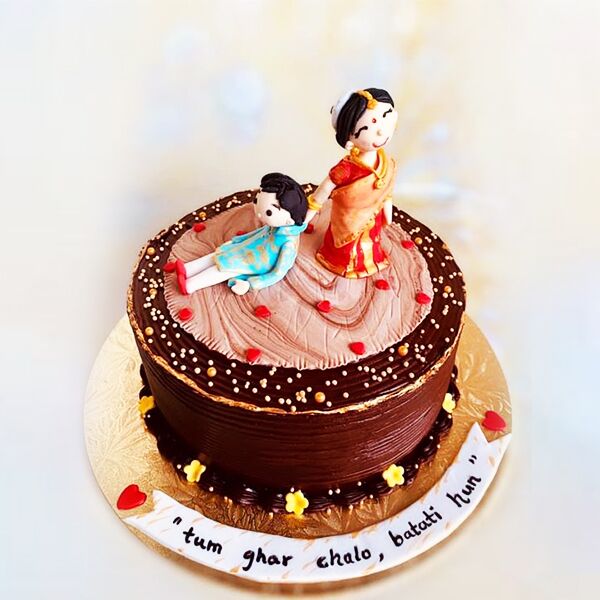 A chocolate cake with bride and groom