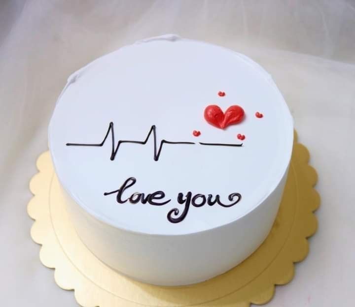 A white cake with a heartbeat line, red heart