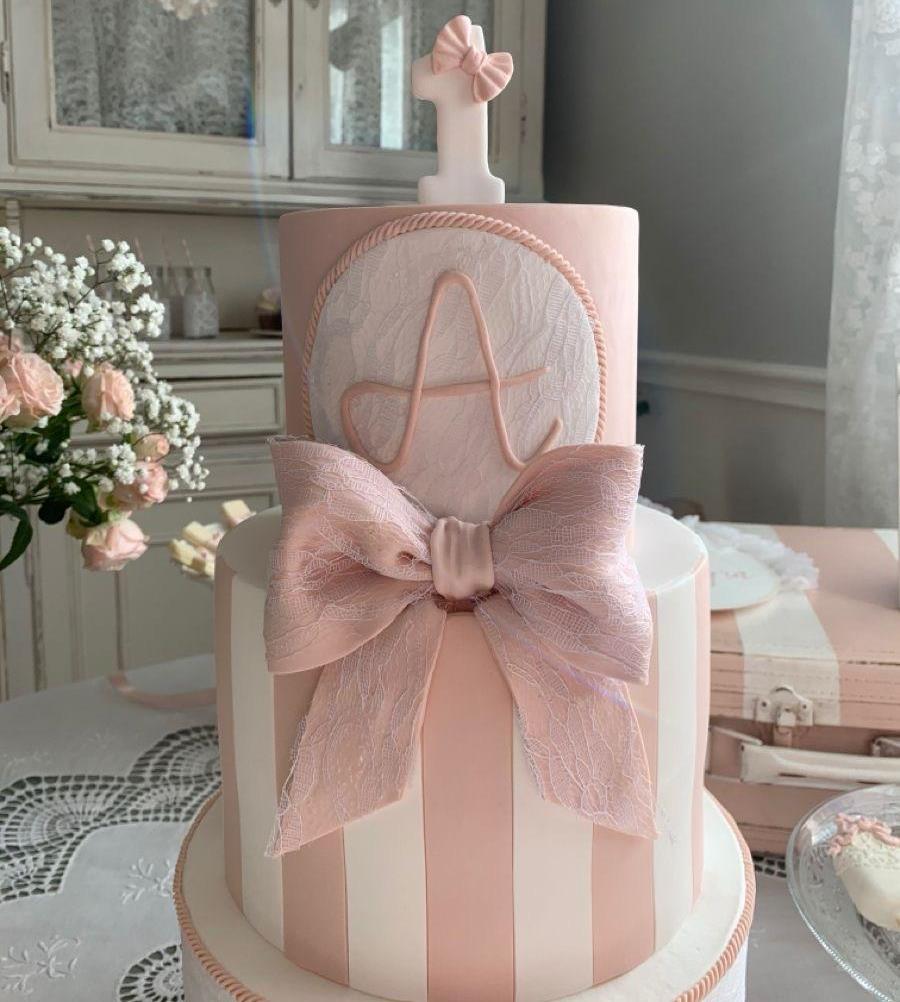 Pink cake with initial 'A' and ballet topper"